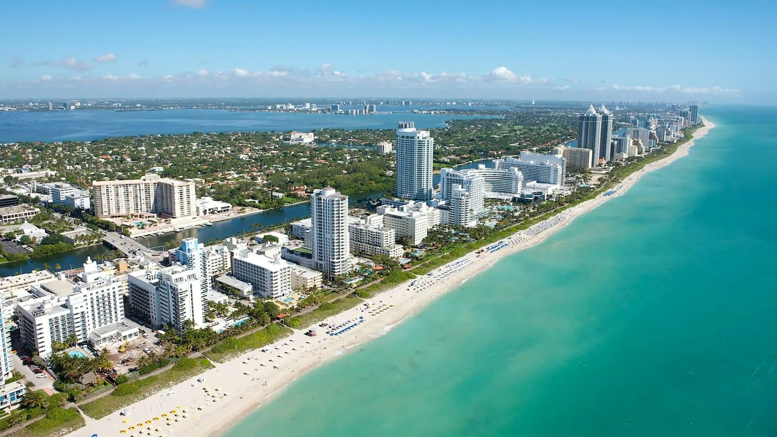 Miami Beacheko oporretako alokairuak - hiriko eraikinen aireko ikuspegia ur-masaren ondoan egunez