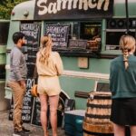a group of people standing outside of a food truck