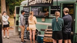 a group of people standing outside of a food truck