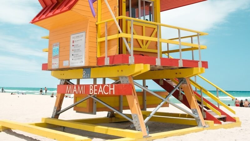 red and white wooden lifeguard house on beach shore during daytime